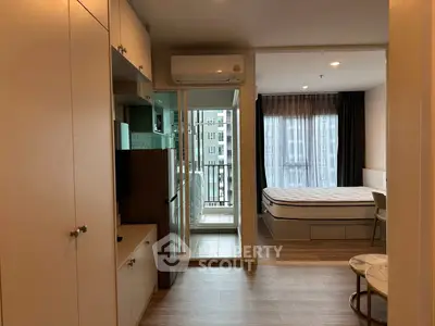 Modern apartment interior with bedroom and balcony view, featuring sleek design and ample natural light.