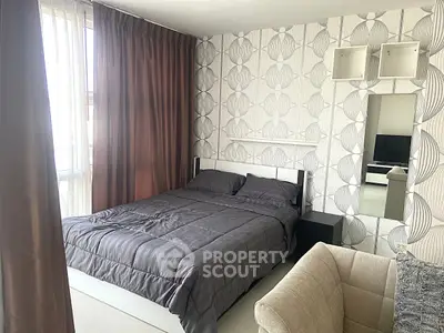 Modern bedroom with stylish wallpaper and cozy furnishings in a bright apartment.