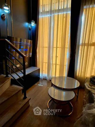 Modern living room with stylish staircase and elegant lighting