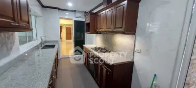 Elegant kitchen with granite countertops and wooden cabinets, featuring a gas stove and modern appliances.