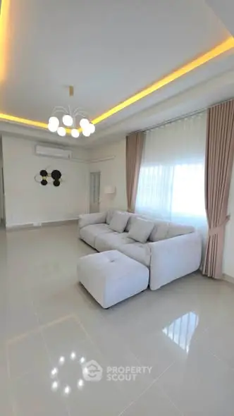 Spacious modern living room with elegant lighting and large windows.
