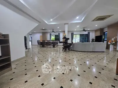 Spacious open-plan living room with elegant tiled flooring and modern furnishings.