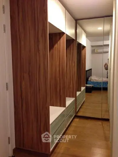 Spacious bedroom with mirrored wardrobe and wooden flooring