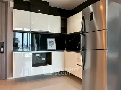 Modern kitchen with sleek cabinets and stainless steel fridge in a stylish apartment.