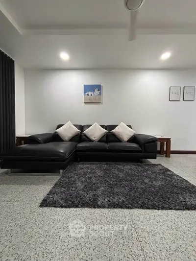 Modern living room with sleek black sofa and stylish decor