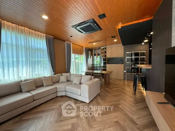 Spacious modern living room with stylish wooden ceiling and large sectional sofa.