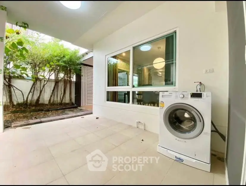 Spacious patio with washing machine and garden view in modern home