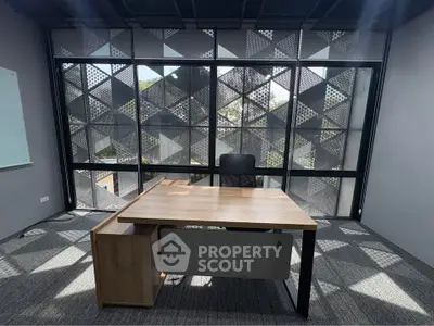 Modern office space with stylish desk and large geometric window design