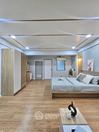 Spacious modern bedroom with wooden flooring and stylish decor