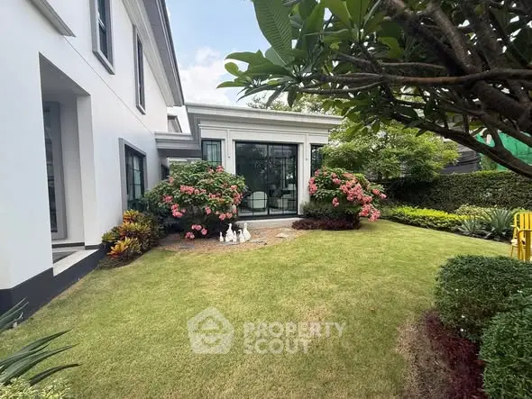 Charming garden view with lush greenery and elegant exterior of a modern home.