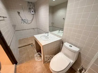 Modern bathroom with tiled walls, shower, and sleek fixtures in a contemporary home.