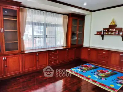 Spacious room with elegant wooden cabinetry and large window, perfect for a cozy living space.