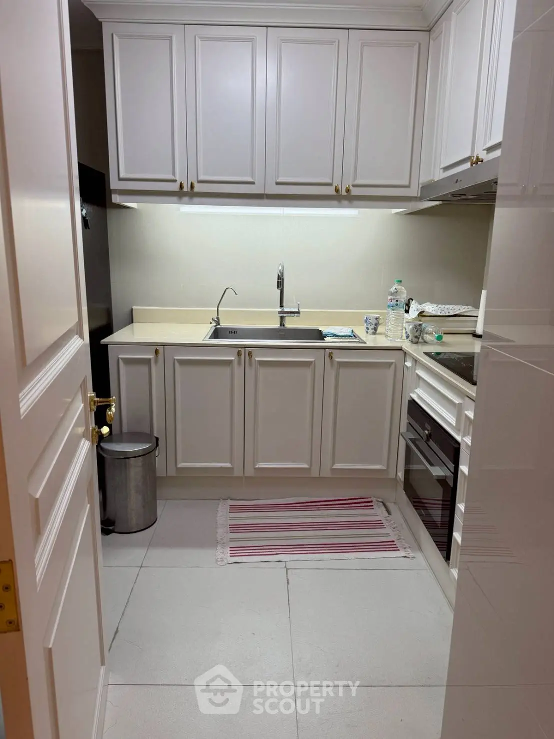 Charming compact kitchen with white cabinetry and modern appliances