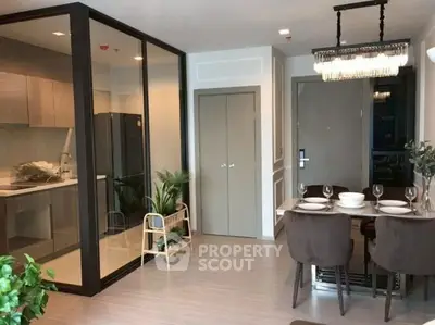 Modern open-plan living area with glass partition and elegant dining setup.