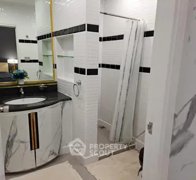 Modern bathroom with elegant marble sink and stylish shower area.