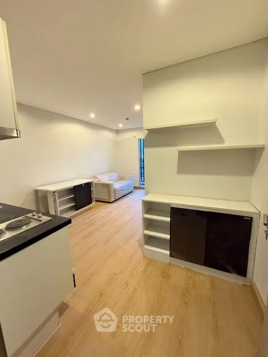 Modern open-plan living room with sleek kitchen and cozy seating area, perfect for urban living.