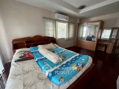 Spacious bedroom with wooden furniture and large windows for natural light