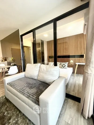 Modern living room with cozy sofa and stylish decor in open-plan apartment.