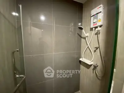 Modern bathroom with sleek shower and water heater in a contemporary apartment.