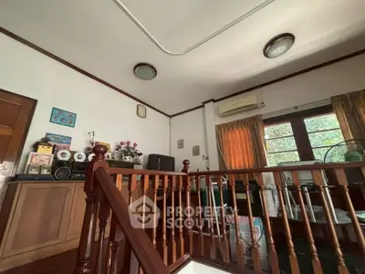 Charming interior with wooden railing and vintage decor in a cozy living space.