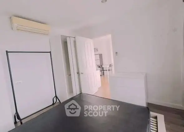 Spacious bedroom with modern furnishings and air conditioning in a bright apartment.