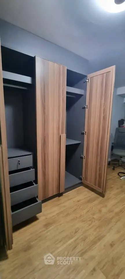 Spacious walk-in closet with modern wooden finish and ample storage space.