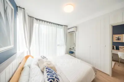 Bright and airy bedroom with large windows and modern decor in a stylish apartment.