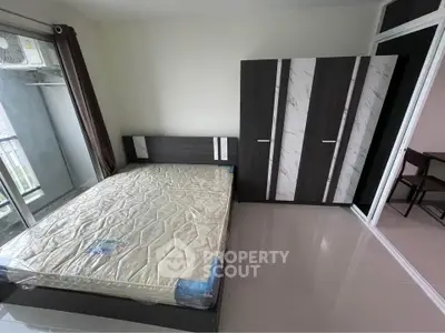 Modern bedroom with large window and sleek wardrobe in a stylish apartment.