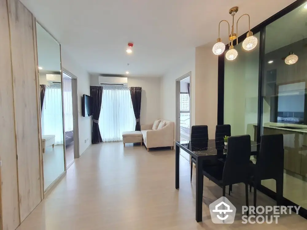 Modern open-plan living room with dining area and stylish lighting in a contemporary apartment.