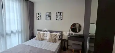 Modern bedroom with stylish decor and natural light, featuring a cozy bed and elegant vanity area.