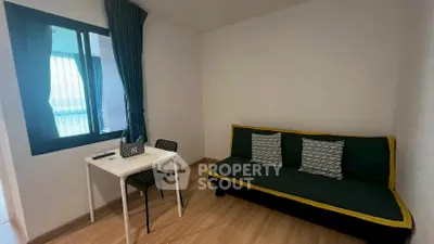 Cozy living room with modern sofa and dining table, perfect for small spaces.