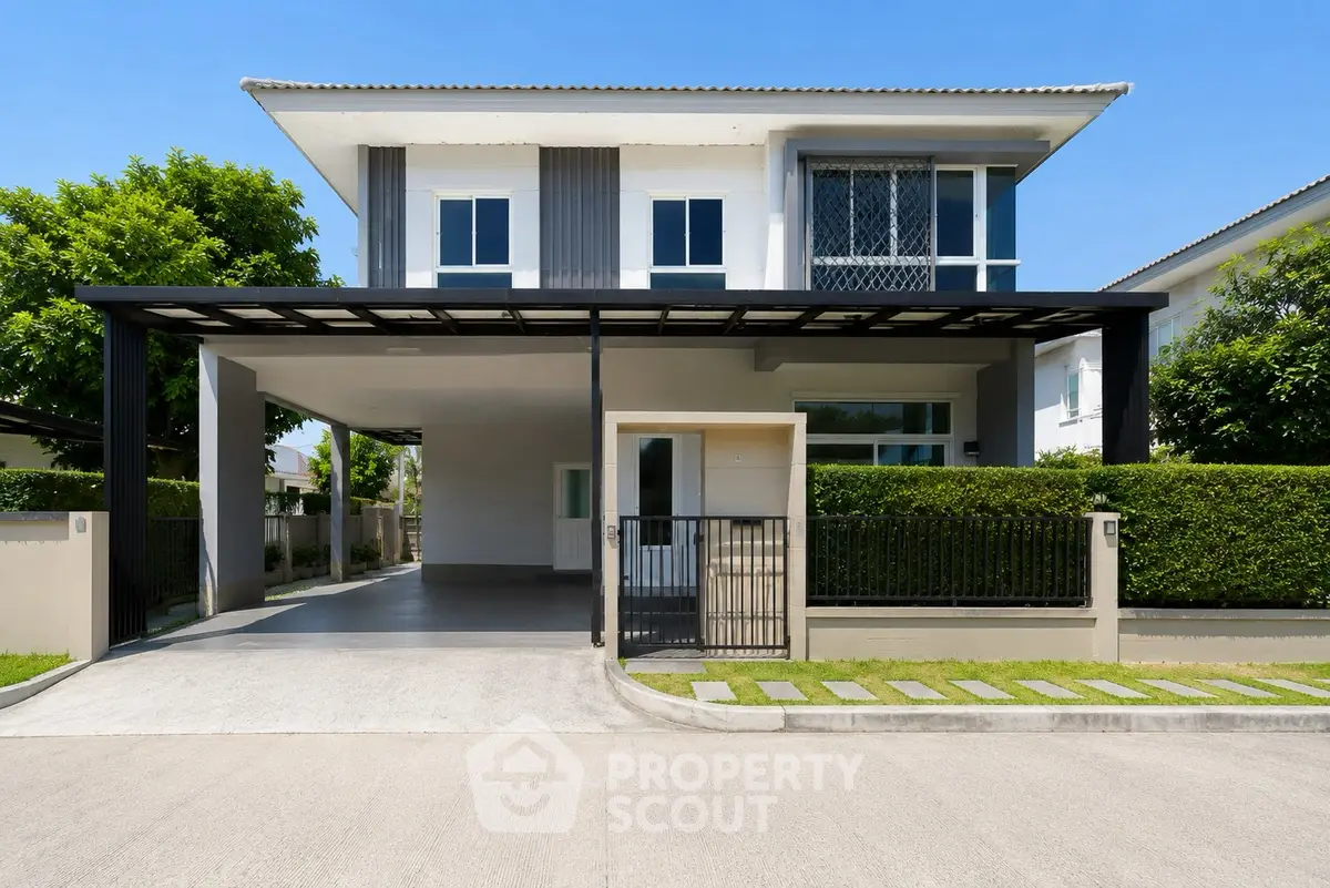 Modern two-story house with sleek design and spacious driveway in a serene neighborhood.