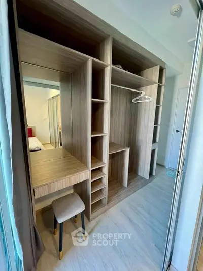 Spacious walk-in closet with modern wooden shelving and vanity area in a stylish apartment.