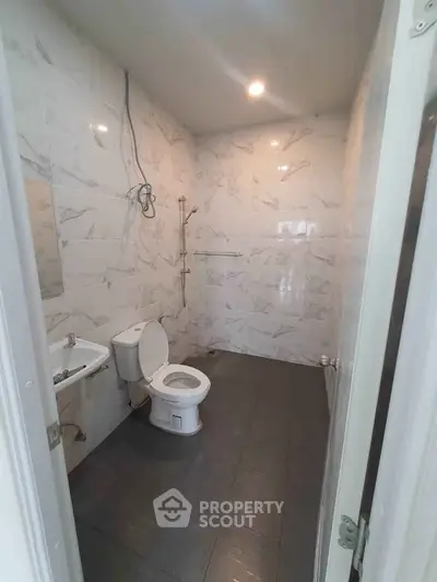 Spacious modern bathroom with elegant marble tiles and sleek fixtures.