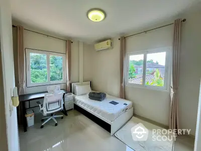 Bright bedroom with single bed, desk, and large windows offering garden views.