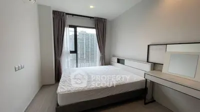 Modern bedroom with large window and city view in high-rise apartment