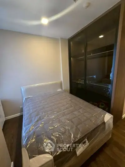 Modern bedroom with cozy bed and sleek wardrobe in stylish apartment.