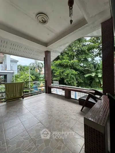 Spacious balcony with tiled flooring and lush green views, perfect for relaxation and outdoor enjoyment.