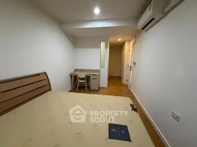 Cozy bedroom with wooden flooring and modern air conditioning unit