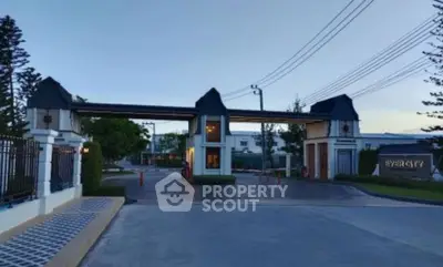 Elegant gated entrance of a modern residential community at dusk.