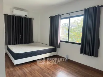 Spacious bedroom with large window and modern decor