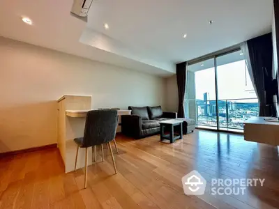 Spacious living room with hardwood floors, modern furniture, and floor-to-ceiling windows offering a panoramic city view.