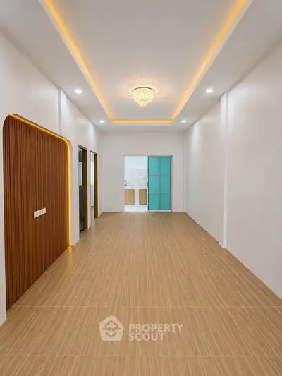 Spacious modern living room with elegant ceiling lights and wooden flooring, perfect for stylish urban living.