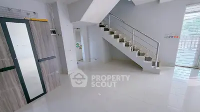 Spacious modern interior with sleek staircase and large windows