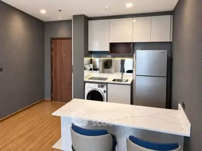 Modern kitchen with sleek appliances and stylish dining area in a contemporary apartment.