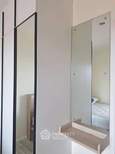 Modern bedroom with sleek mirrored wardrobe and minimalist design