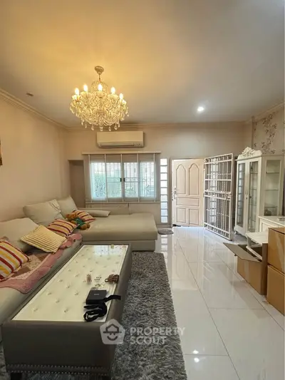 Elegant living room with chandelier, plush sofa, and glossy tile flooring, perfect for modern family living.