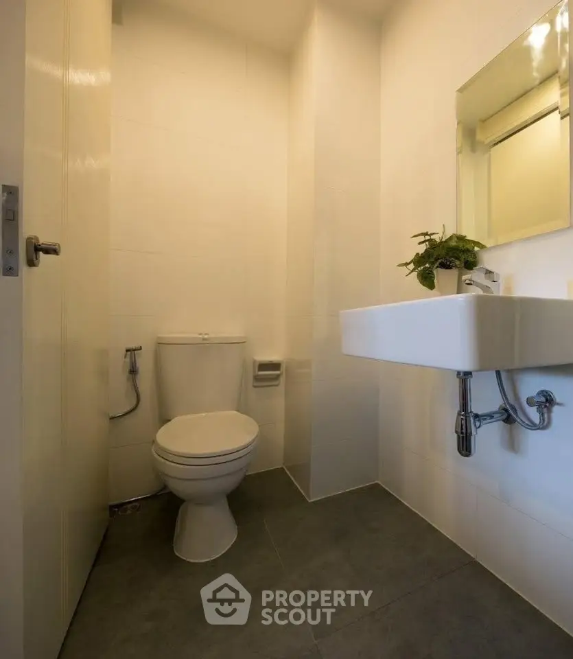 Compact modern bathroom with sleek fixtures and minimalist design.