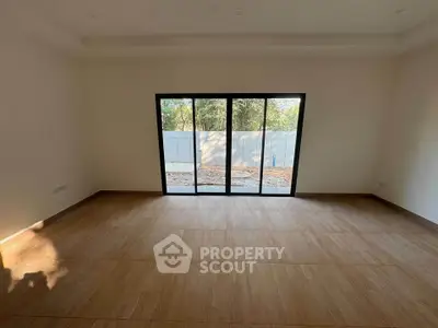 Spacious room with large windows offering natural light and garden view, perfect for modern living.