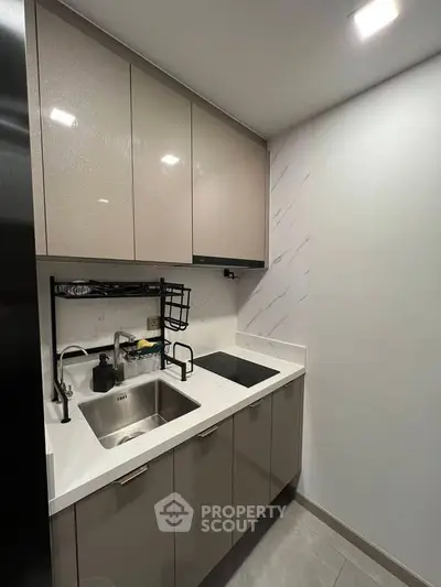 Modern compact kitchen with sleek cabinetry and induction cooktop